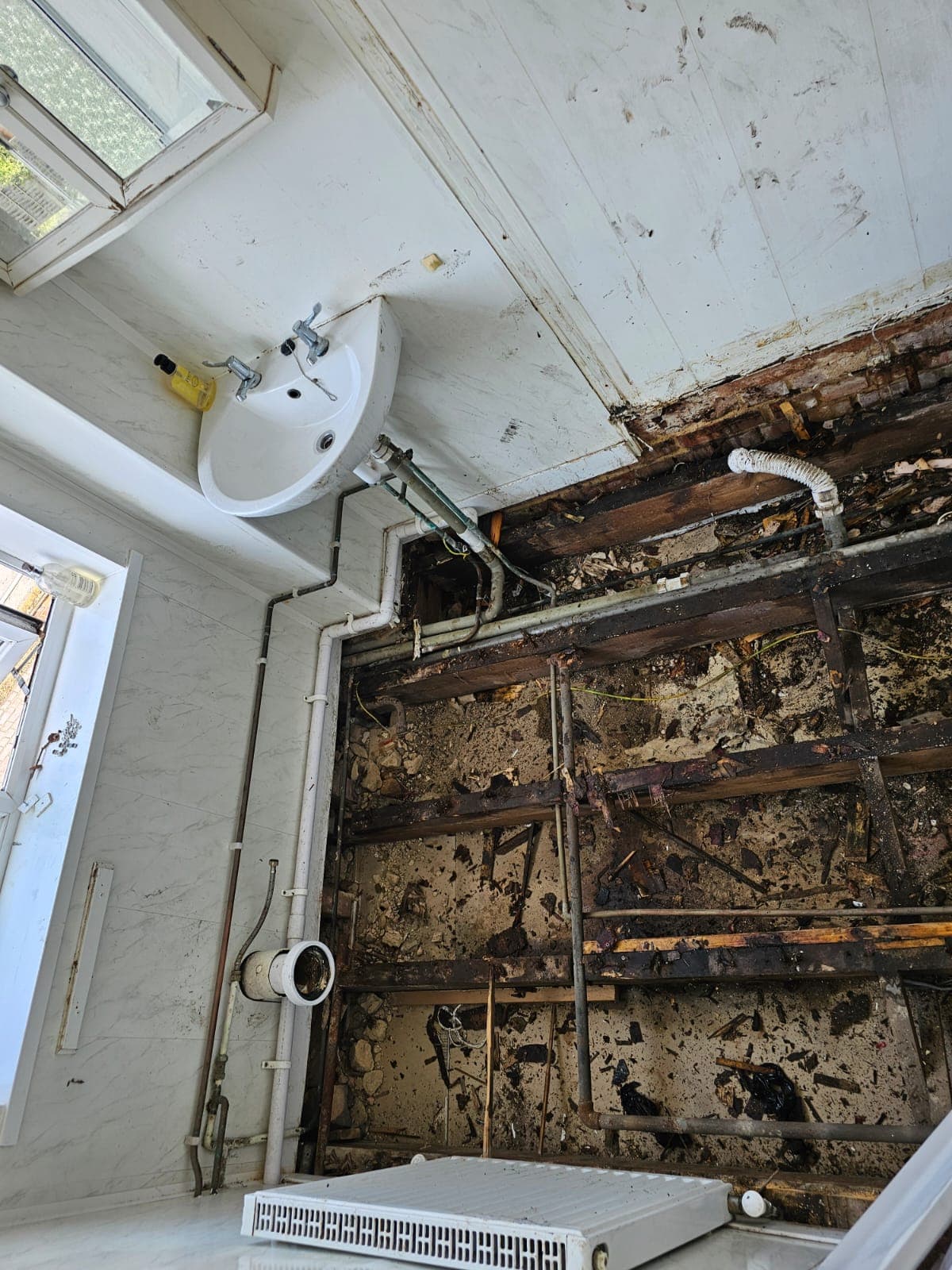 Bathroom mid-renovation — pipework and plastering stage