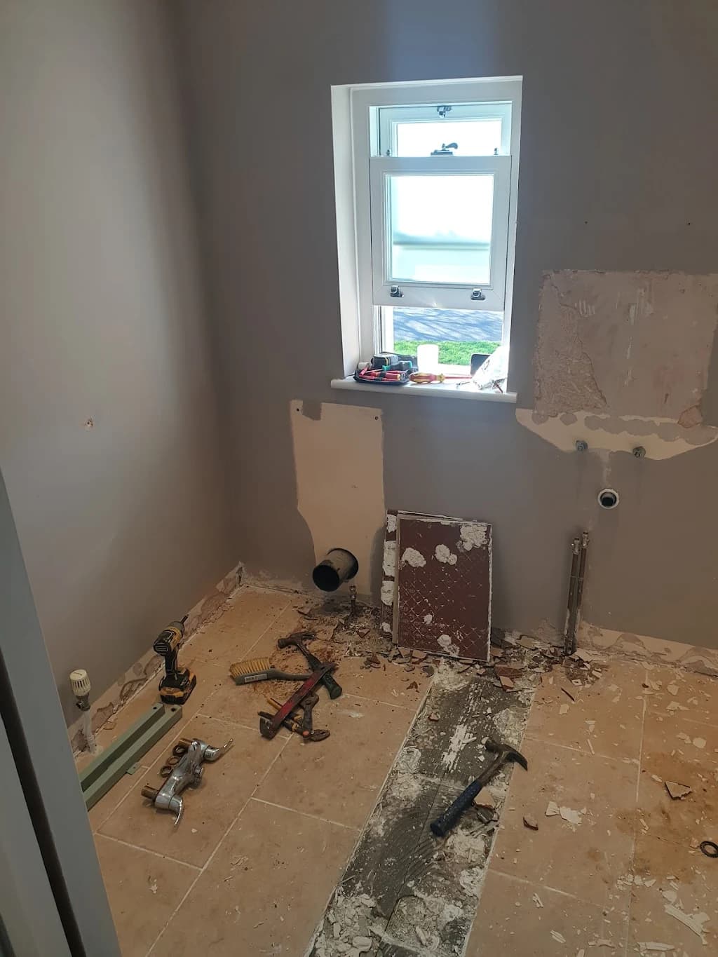 Bathroom stripped back to bare walls and floor, ready for the new layout